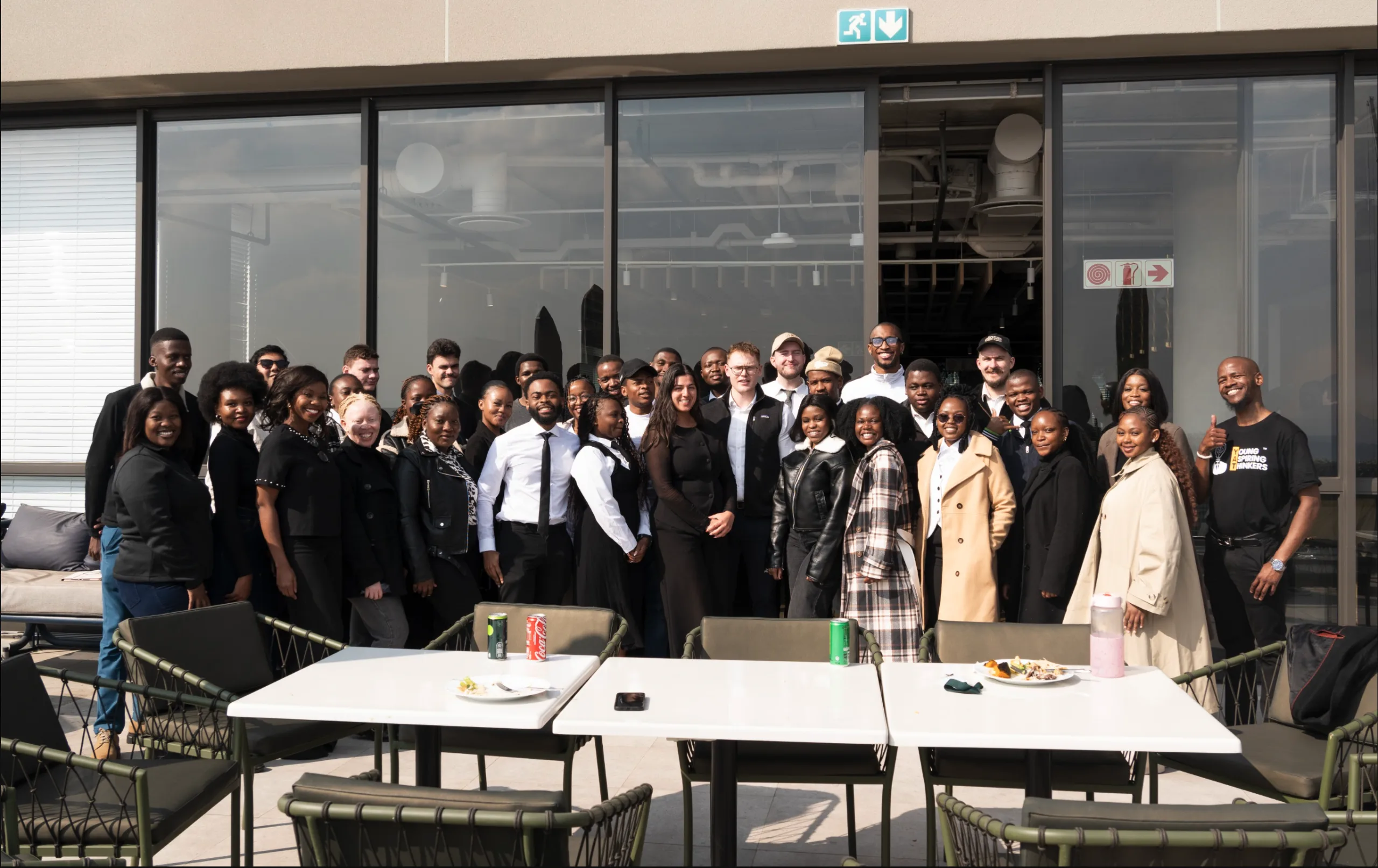 A large group from YAT and its programmes standing together on a rooftop terrace