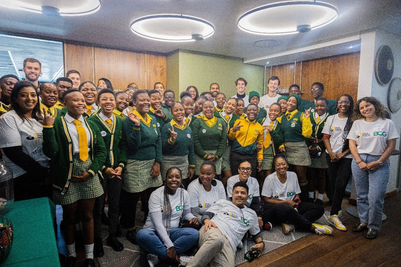 A room full of learners in school uniform with the volunteers who ran their career exposure day